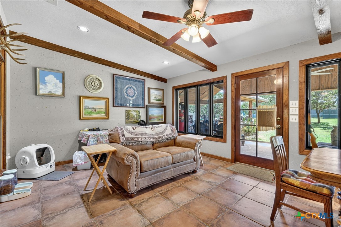 725 County Road 300 Hamilton, TX 76531 - Photo 9 of 41 a living room with furniture a flat screen tv and a floor to ceiling window