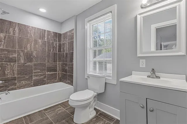 a bathroom with a sink toilet a vanity and bathtub