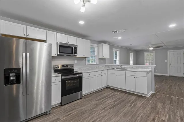 a kitchen with white cabinets and stainless steel appliances