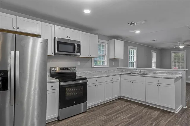 a kitchen with stainless steel appliances granite countertop a stove a sink and a refrigerator