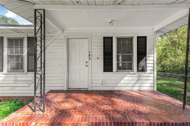 a view of house with backyard and glass windows