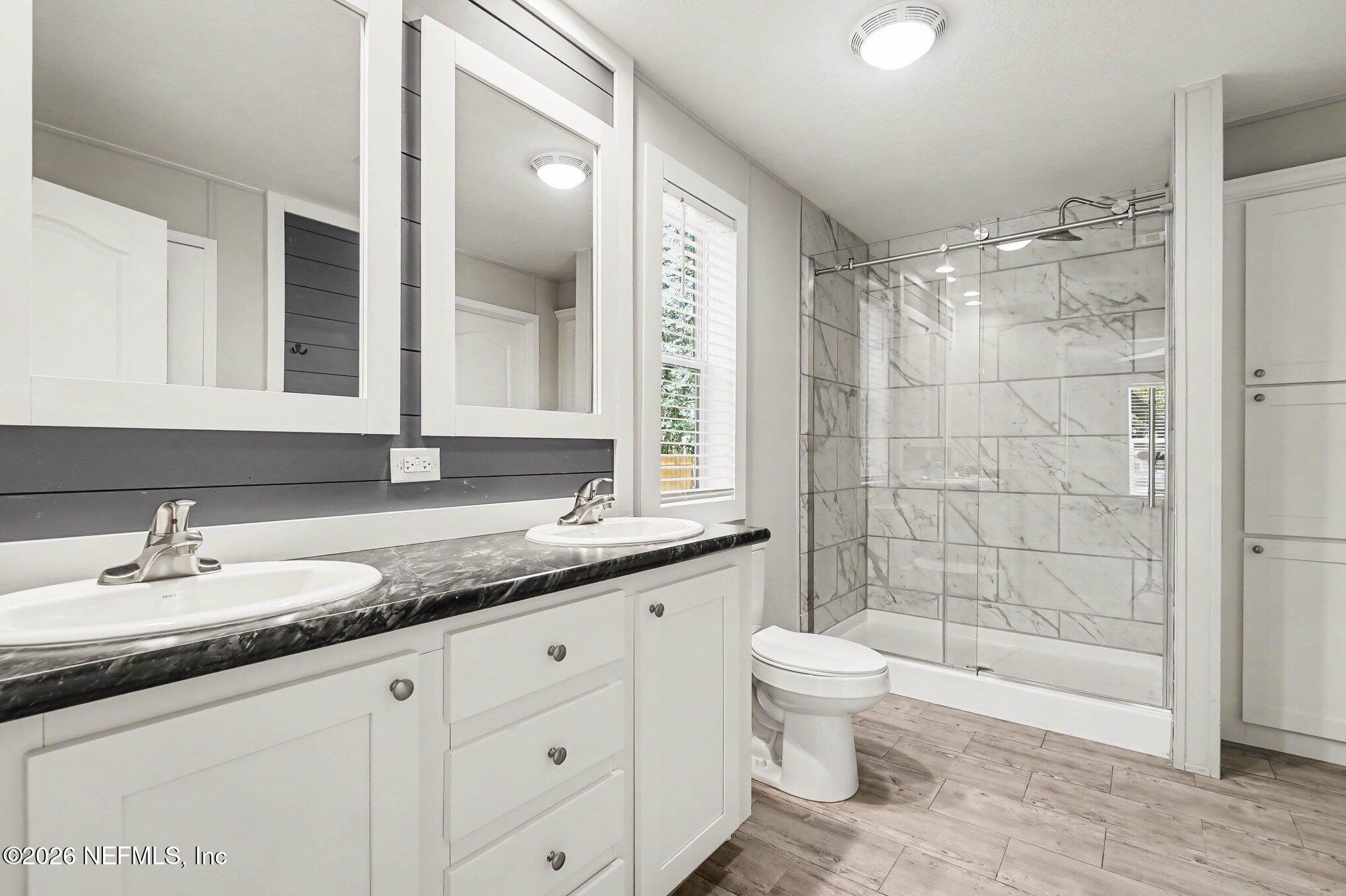 85083 Condor Lane Yulee, FL 32097 - Photo 12 of 32 a bathroom with a granite countertop sink a toilet and shower