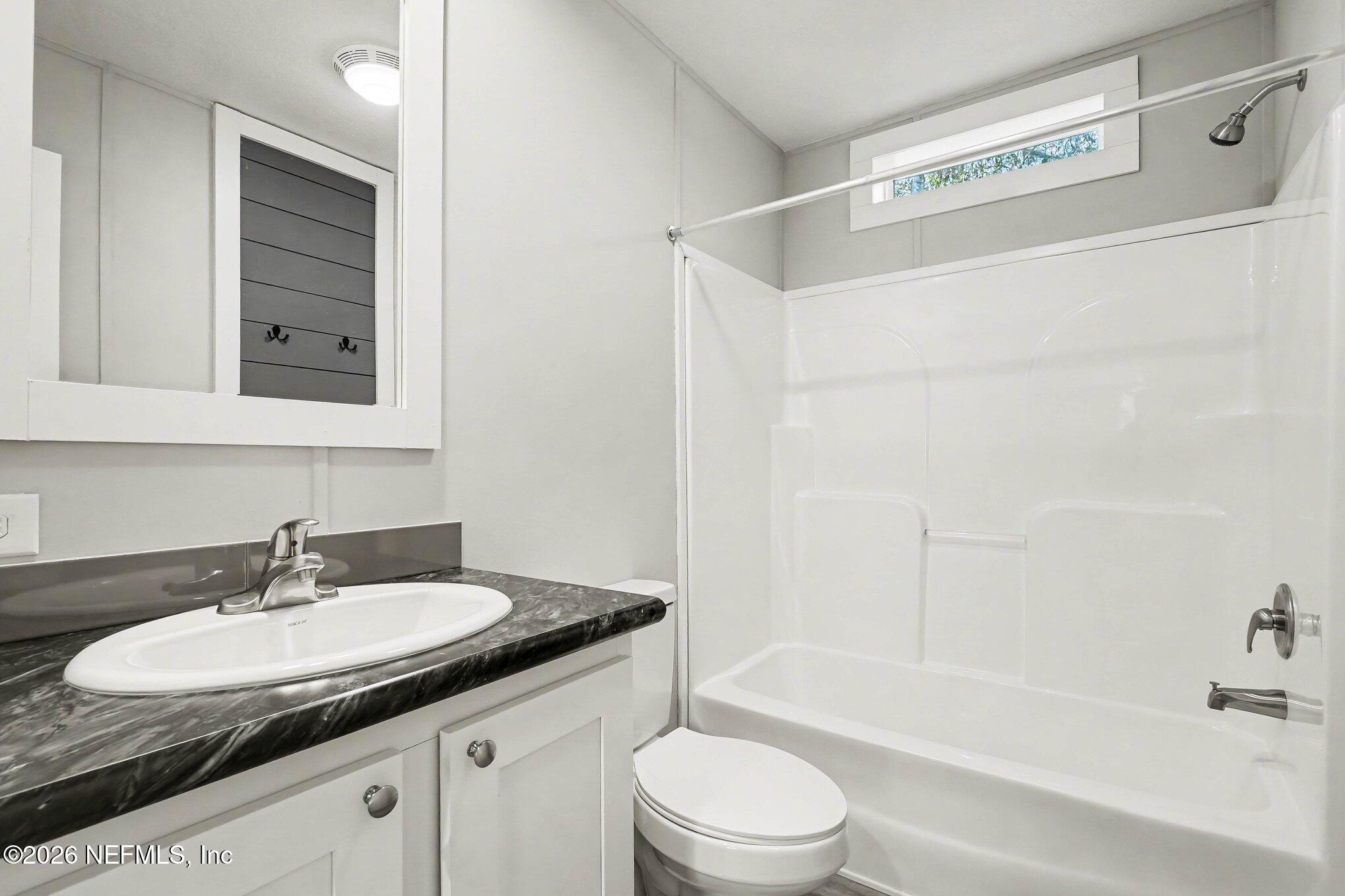 85083 Condor Lane Yulee, FL 32097 - Photo 16 of 32 a bathroom with a granite countertop sink a toilet and shower