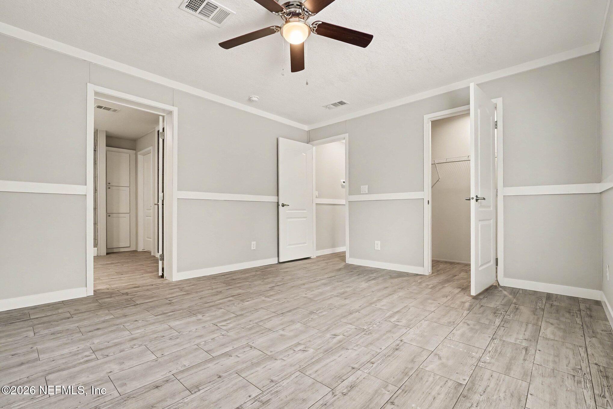 85083 Condor Lane Yulee, FL 32097 - Photo 20 of 32 a view of an empty room with wooden floor and a ceiling fan