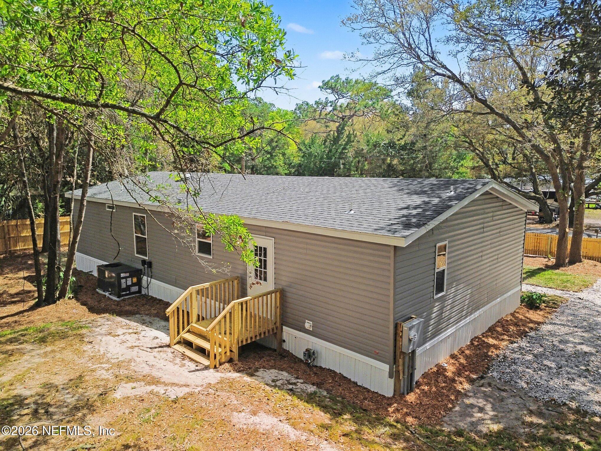 85083 Condor Lane Yulee, FL 32097 - Photo 26 of 32 a view of a backyard with a chair and a tree