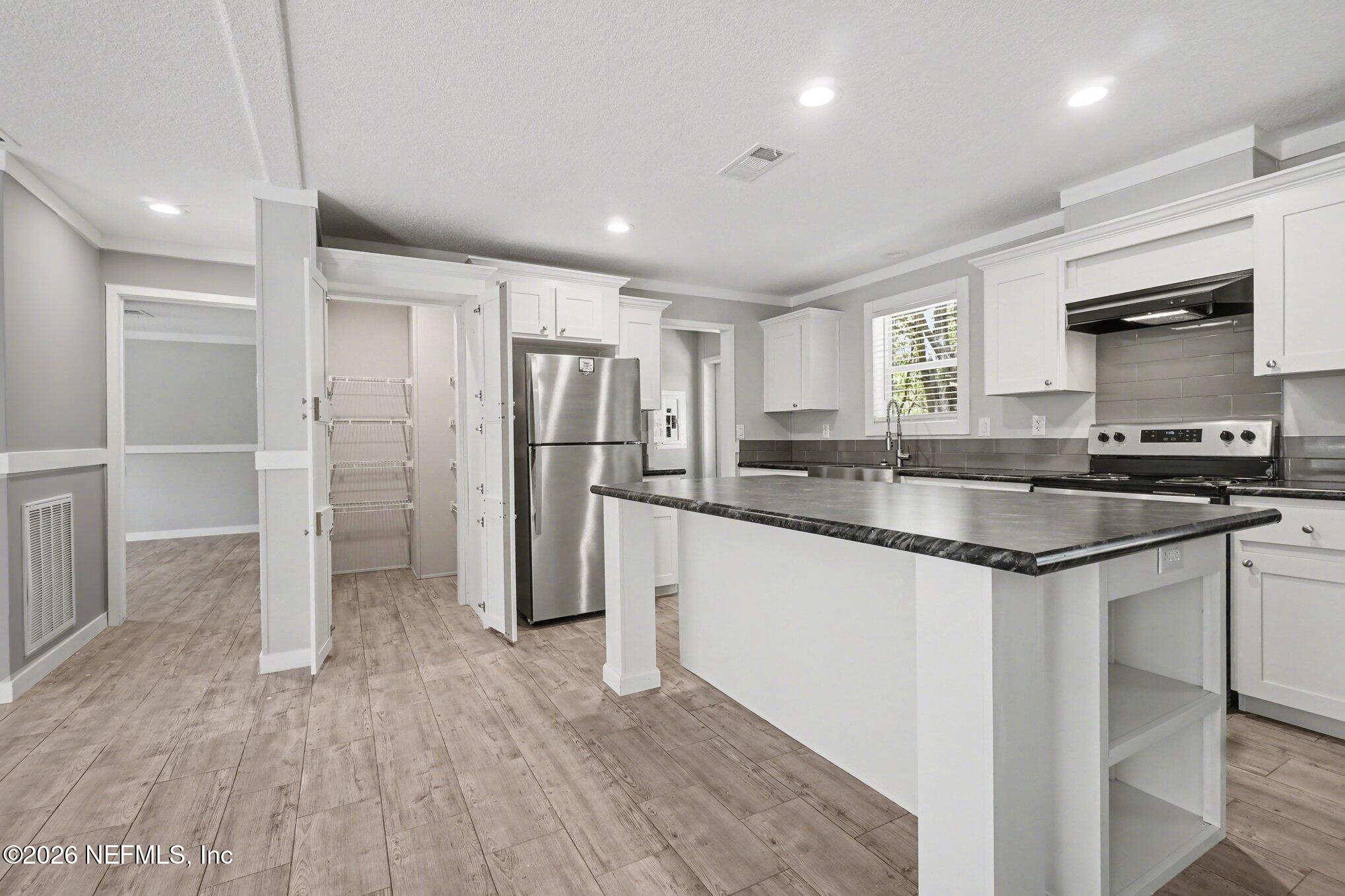 85083 Condor Lane Yulee, FL 32097 - Photo 4 of 32 a kitchen with stainless steel appliances granite countertop a refrigerator and a sink