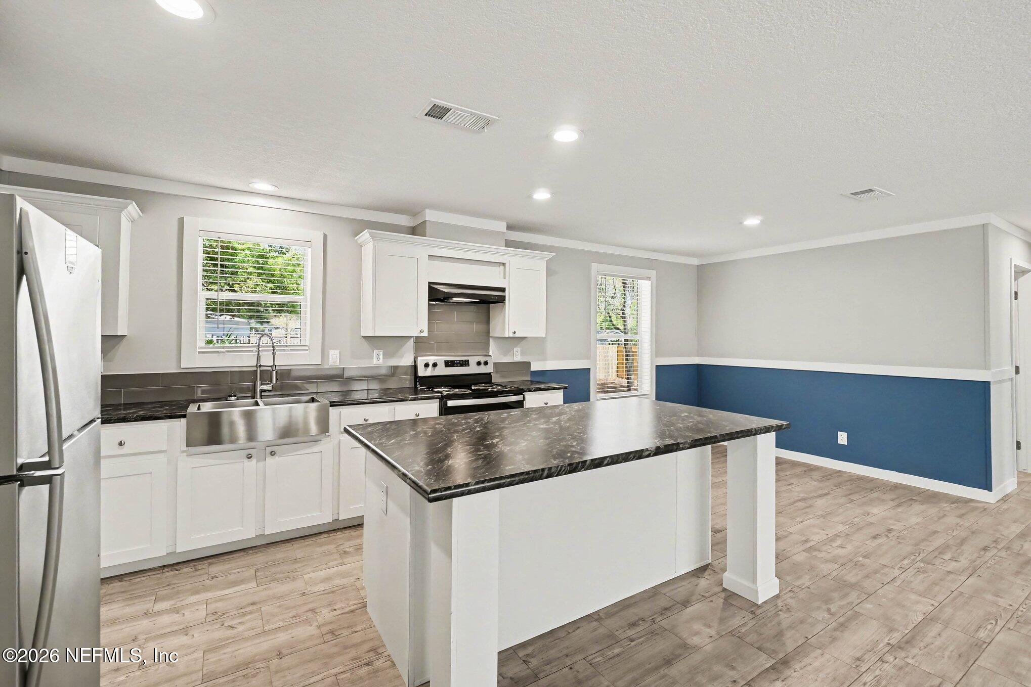 85083 Condor Lane Yulee, FL 32097 - Photo 8 of 32 a kitchen with stainless steel appliances granite countertop a sink stove and refrigerator
