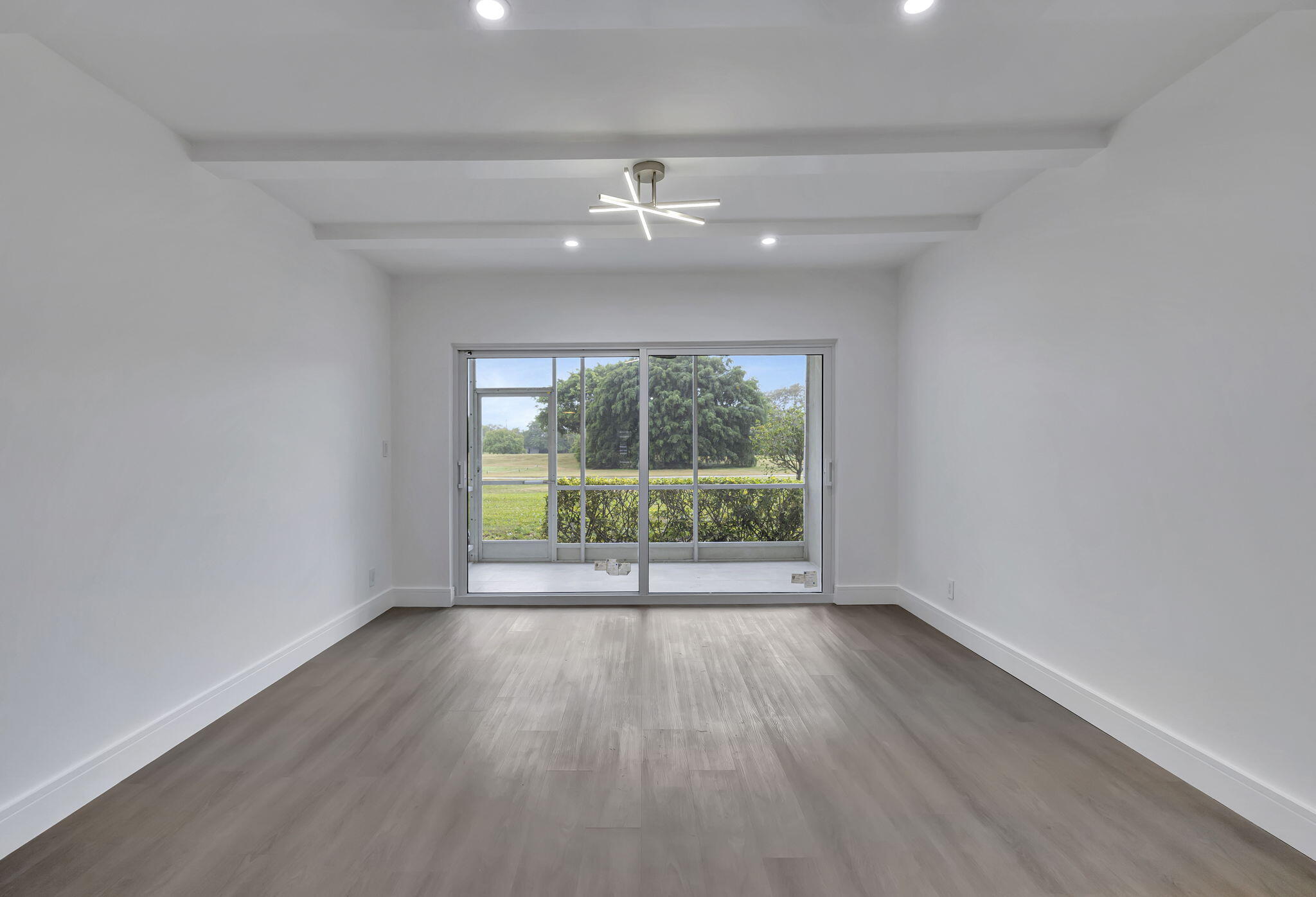 3100 North Palm Aire Drive, Unit 106 Pompano Beach, FL 33069 - Photo 11 of 42 wooden floor in an empty room with a window