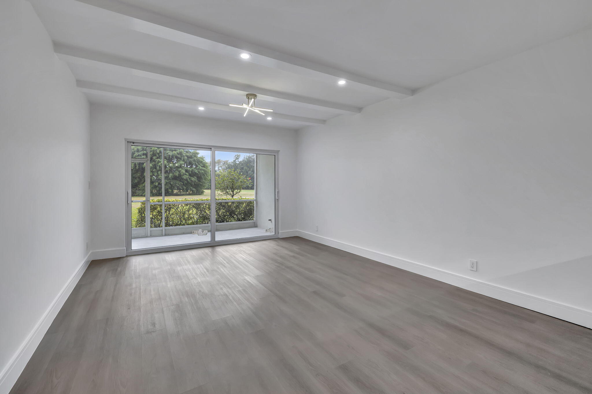 3100 North Palm Aire Drive, Unit 106 Pompano Beach, FL 33069 - Photo 12 of 42 wooden floor in an empty room with a window