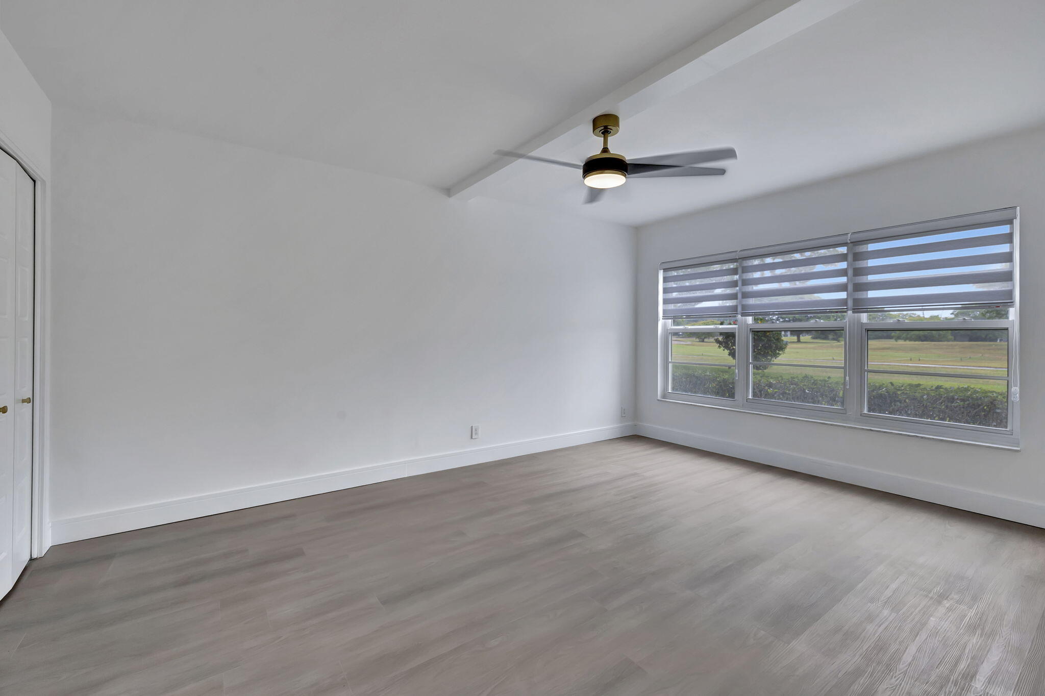 3100 North Palm Aire Drive, Unit 106 Pompano Beach, FL 33069 - Photo 15 of 42 wooden floor in an empty room with a window