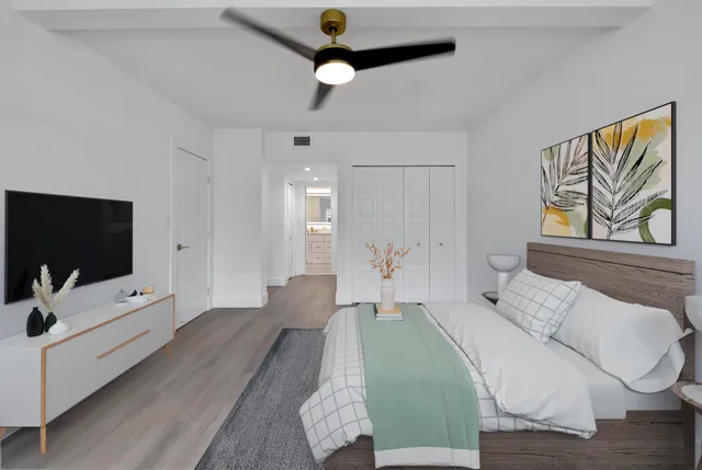 a spacious bedroom with a bed and a flat screen tv