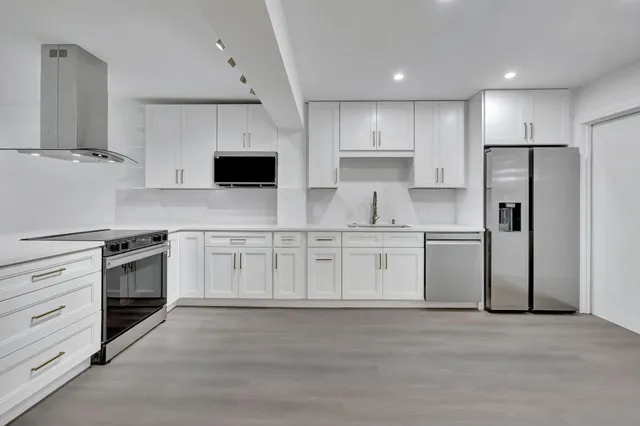 a kitchen with white cabinets and stainless steel appliances