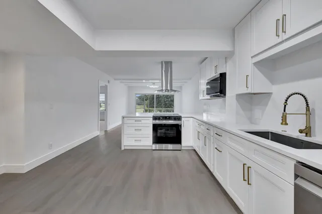 a kitchen with stainless steel appliances a white stove top oven and sink