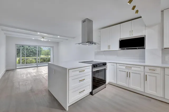 a kitchen with stainless steel appliances white cabinets and a stove top oven