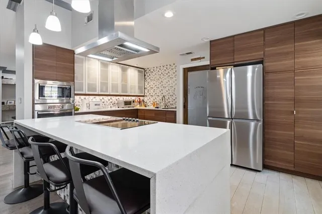 a kitchen with stainless steel appliances a table chairs and refrigerator