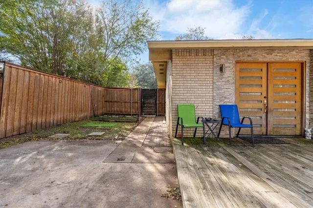 a backyard of a house with chairs and a yard