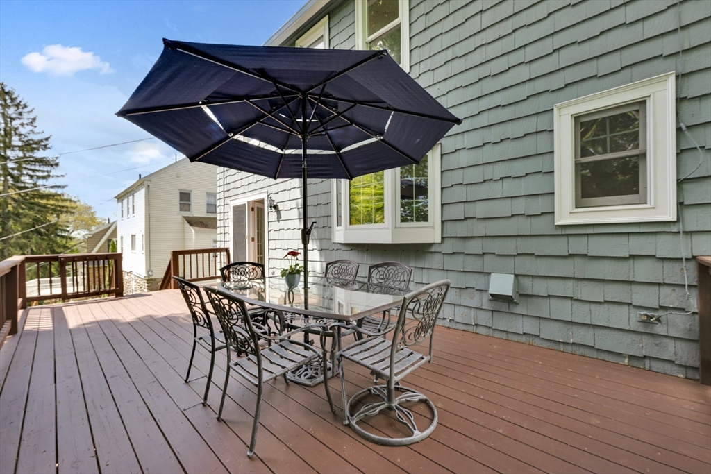 71 Morningside Road Worcester, MA 01602 - Photo 30 of 42 a view of a backyard with table and chairs under an umbrella with wooden floor and fence
