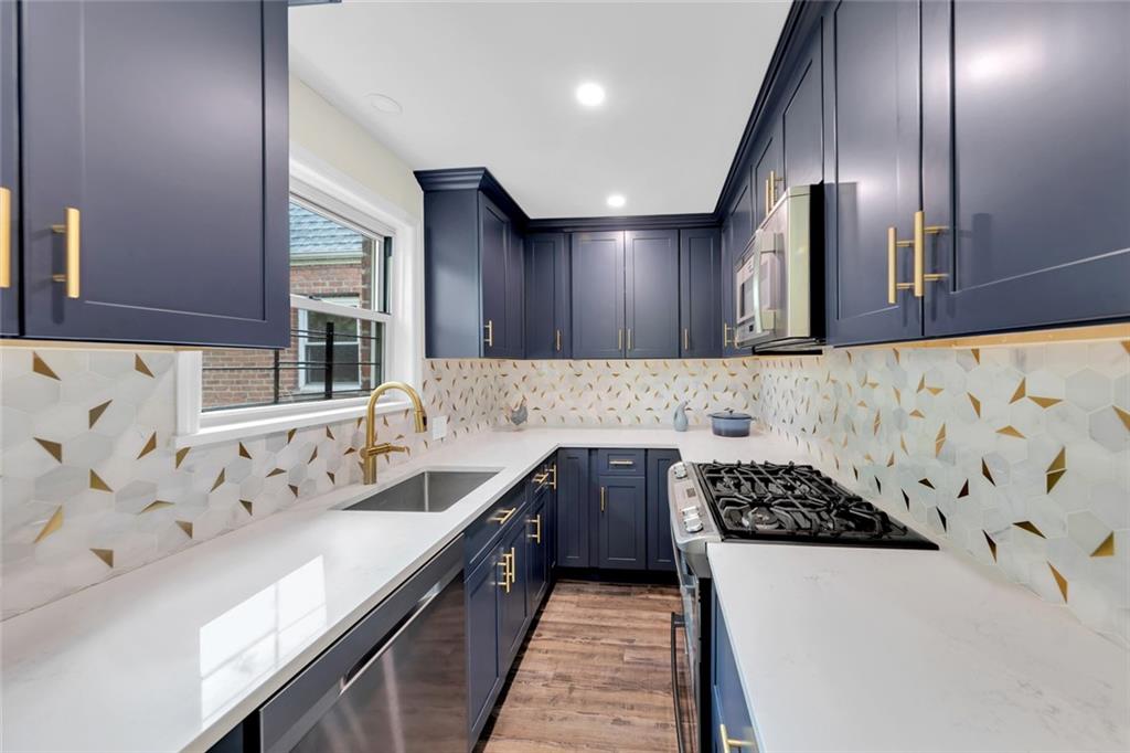 349 Bay 8th Street, Unit 2B Brooklyn, NY 11228 - Photo 2 of 11 a kitchen with stainless steel appliances granite countertop a sink stove and cabinets