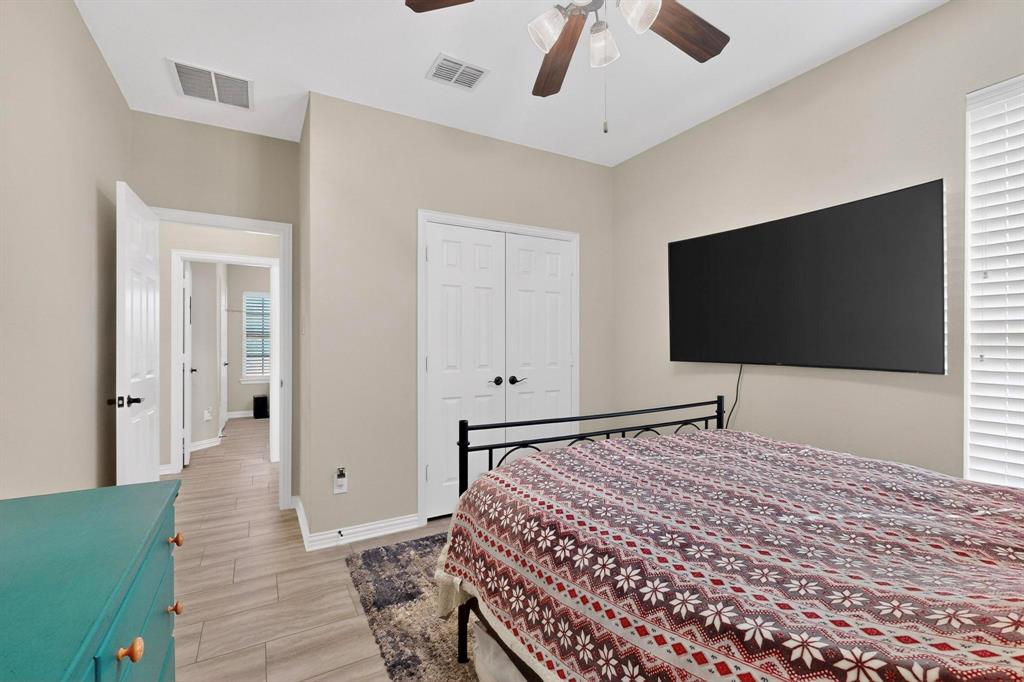 7625 Ridgedale Court Sachse, TX 75048 - Photo 21 of 40 a bedroom with a bed and a flat screen tv