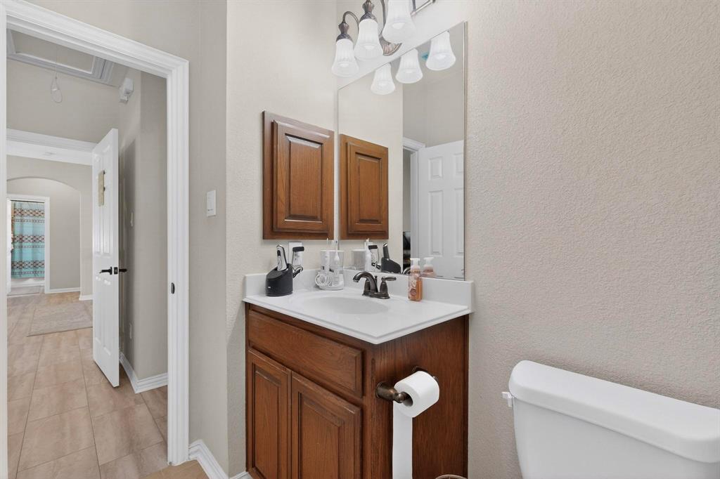 7625 Ridgedale Court Sachse, TX 75048 - Photo 30 of 40 a bathroom with a sink a toilet and mirror