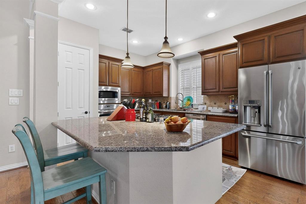 7625 Ridgedale Court Sachse, TX 75048 - Photo 9 of 40 a kitchen with stainless steel appliances granite countertop a sink refrigerator and microwave