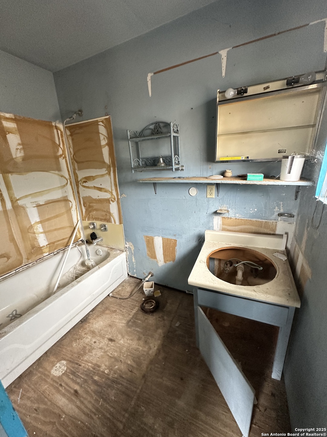 10498 Hollowell Road Atascosa, TX 78002 - Photo 5 of 11 a kitchen with a sink a stove and a wooden floor