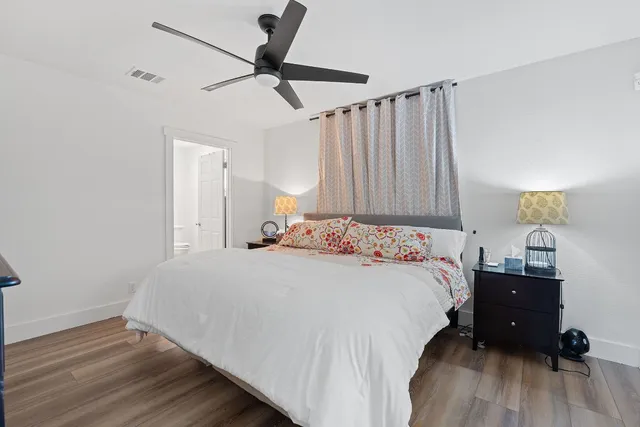 a bedroom with a bed and a wooden floor