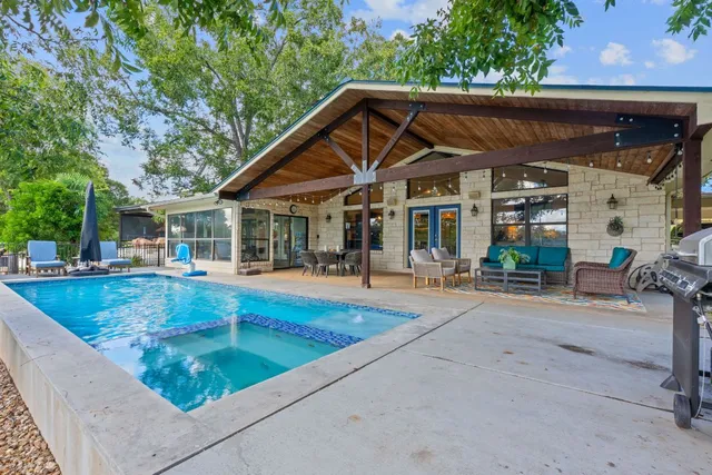 a view of house with swimming pool and sitting area