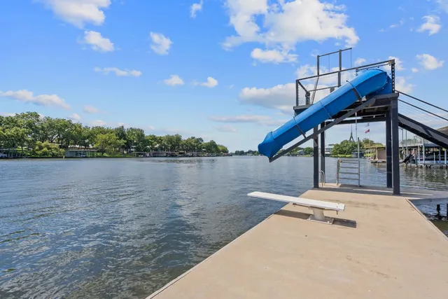 a view of an ocean with boats and trees in the background