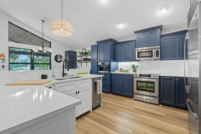a kitchen with stainless steel appliances granite countertop a stove sink and microwave