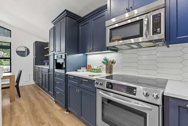 a kitchen with stainless steel appliances a stove a microwave and wooden cabinets