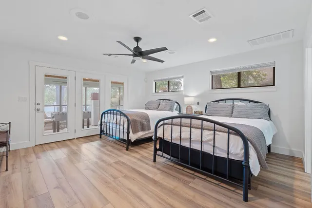 a spacious bedroom with two beds and wooden floor