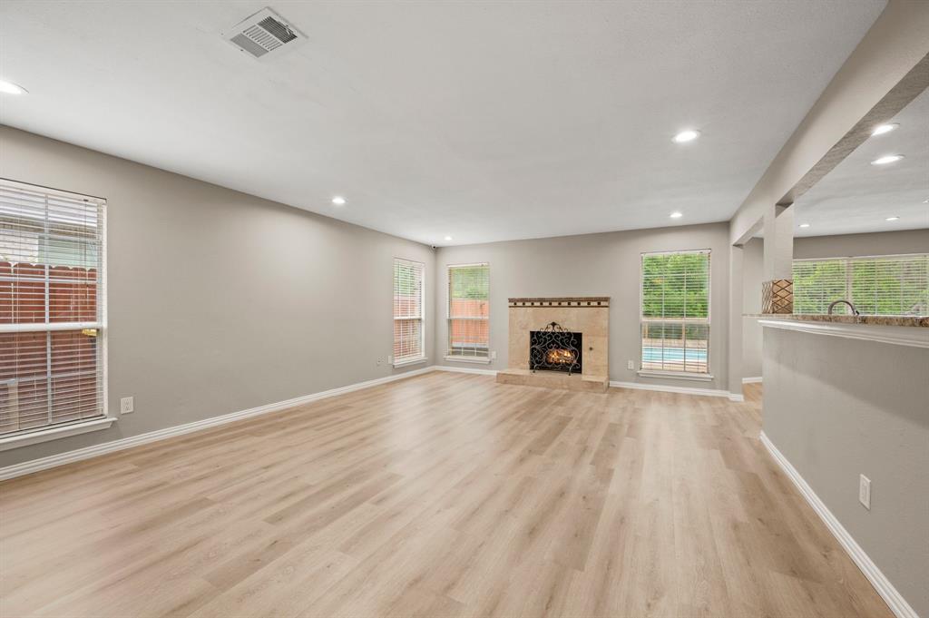 2704 Ridgemere Drive Flower Mound, TX 75028 - Photo 11 of 40 an empty room with windows fireplace and wooden floor