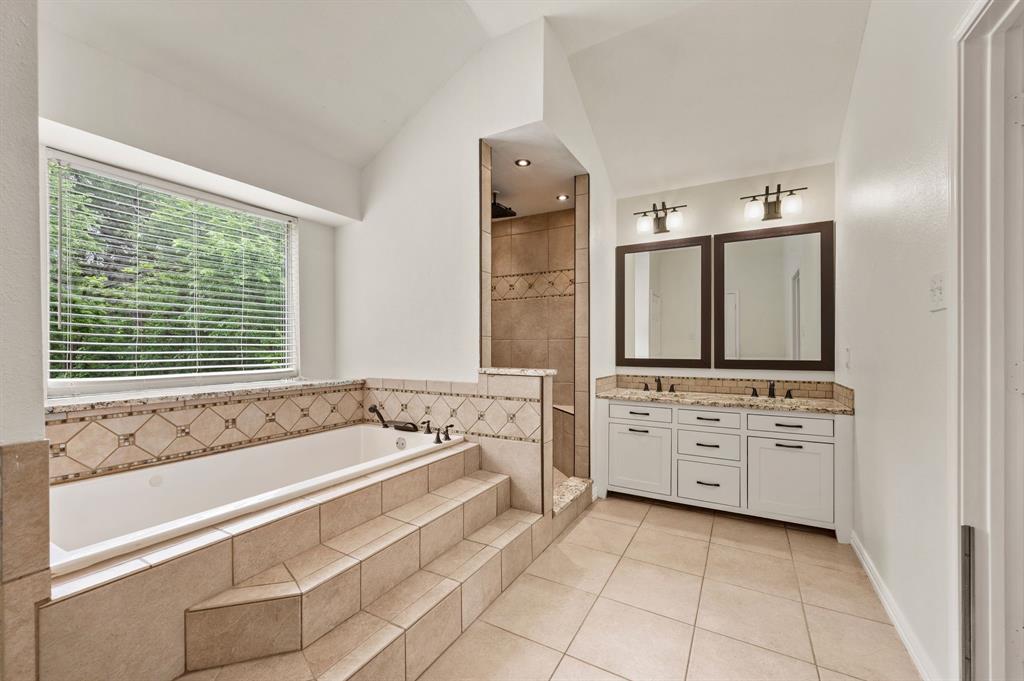 2704 Ridgemere Drive Flower Mound, TX 75028 - Photo 28 of 40 a spacious en suite bathroom with a granite countertop tub and a large mirror