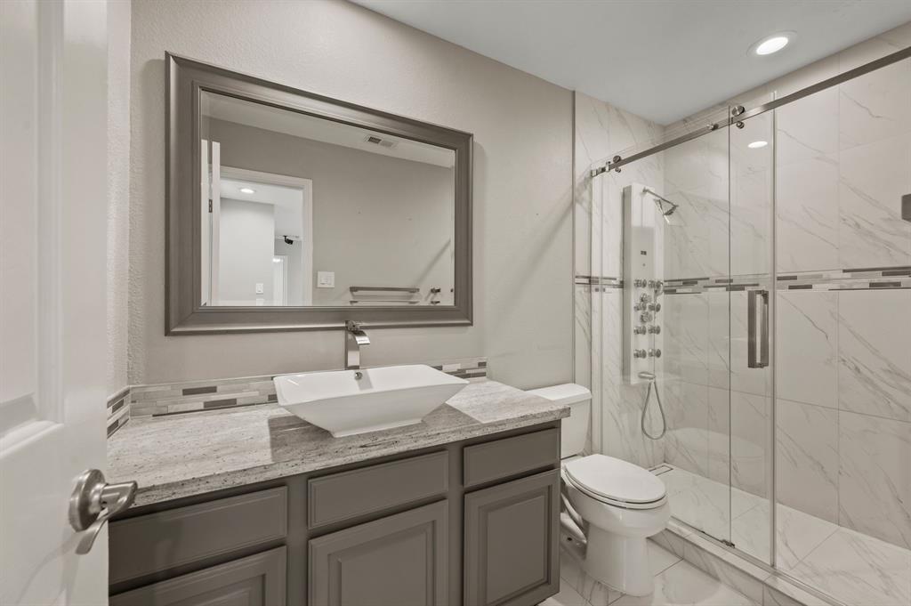 2704 Ridgemere Drive Flower Mound, TX 75028 - Photo 32 of 40 a bathroom with a granite countertop sink toilet and shower