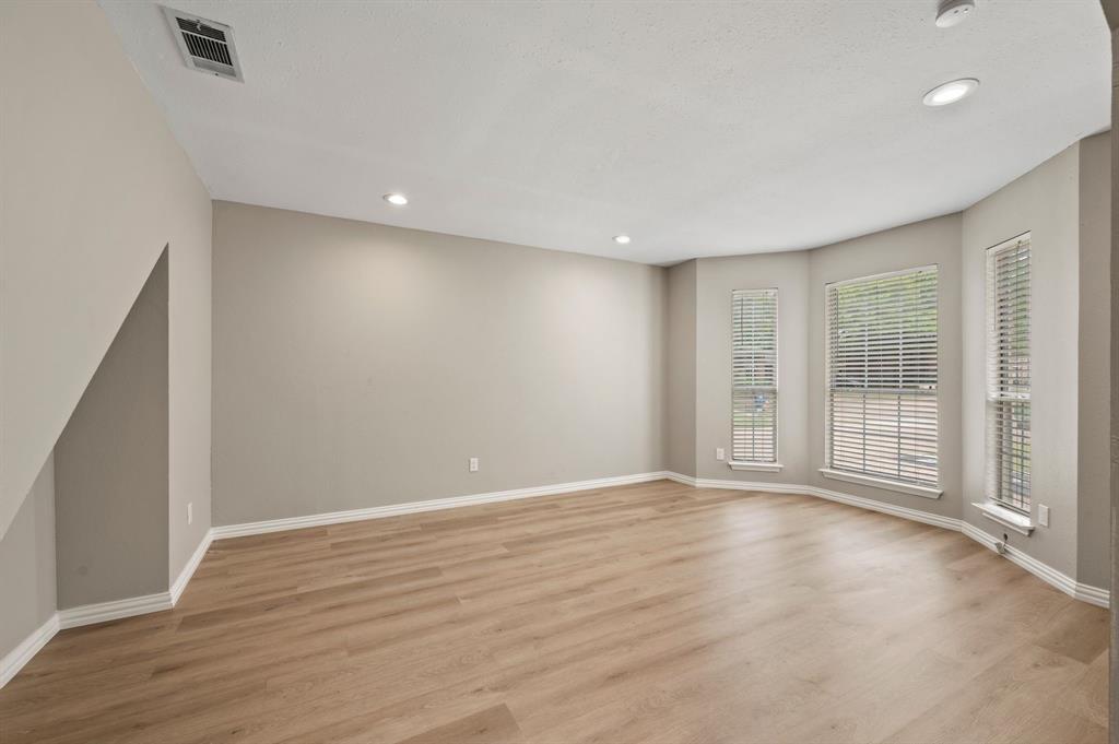 2704 Ridgemere Drive Flower Mound, TX 75028 - Photo 5 of 40 a view of an empty room with wooden floor and a window