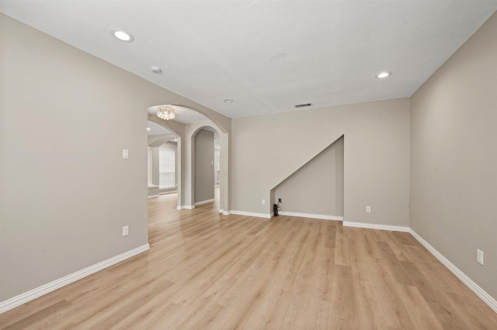 2704 Ridgemere Drive Flower Mound, TX 75028 - Photo 6 of 40 a view of an empty room with wooden floor and a window