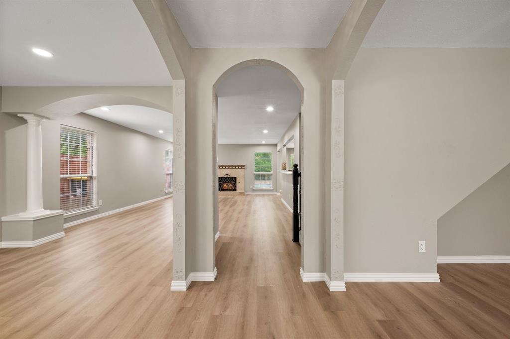 2704 Ridgemere Drive Flower Mound, TX 75028 - Photo 7 of 40 a view of a hallway view with wooden floor and a living room