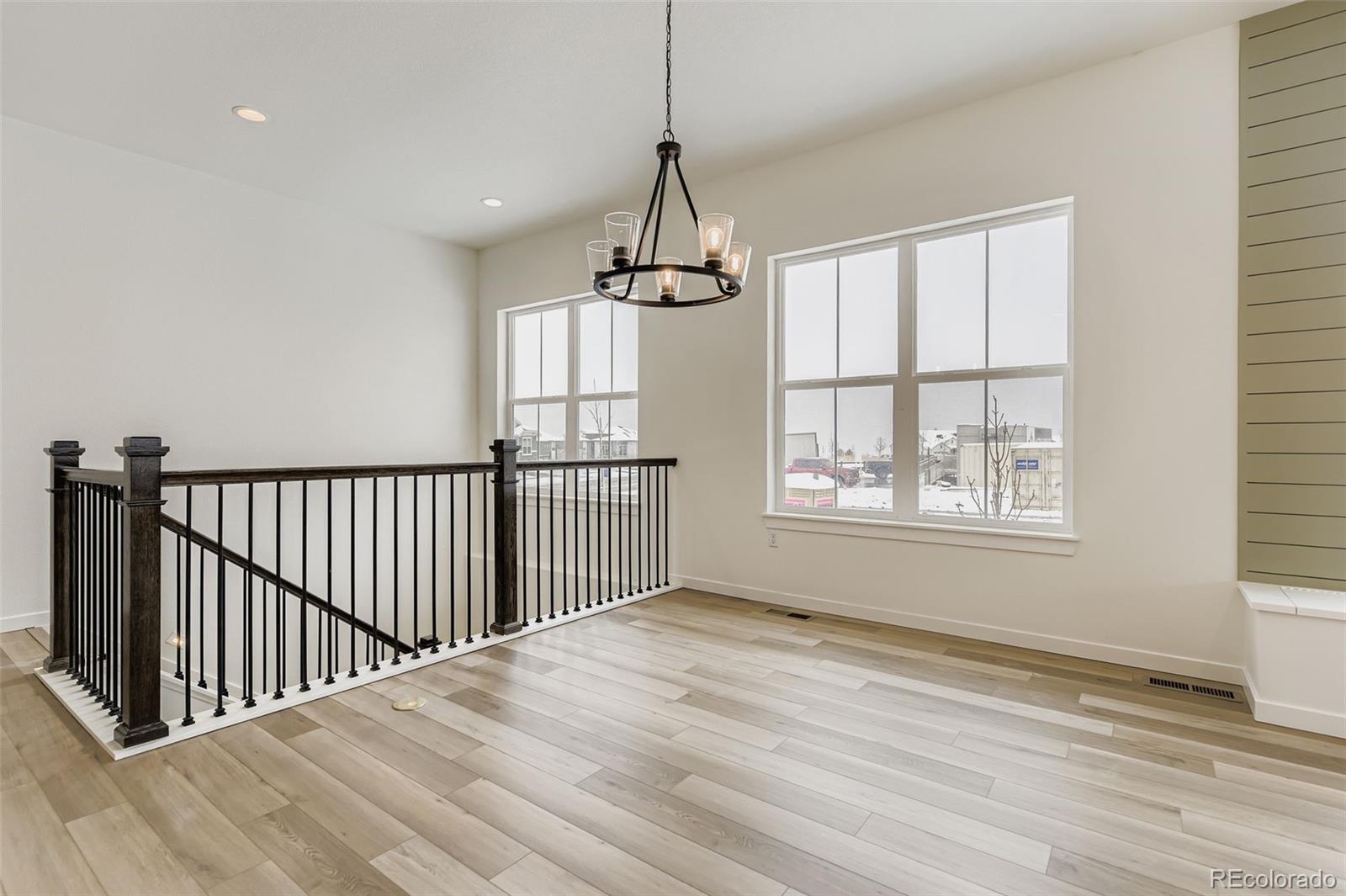 8902 South Riviera Way Aurora, CO 80016 - Photo 11 of 26 a view of an empty room with wooden floor and a window