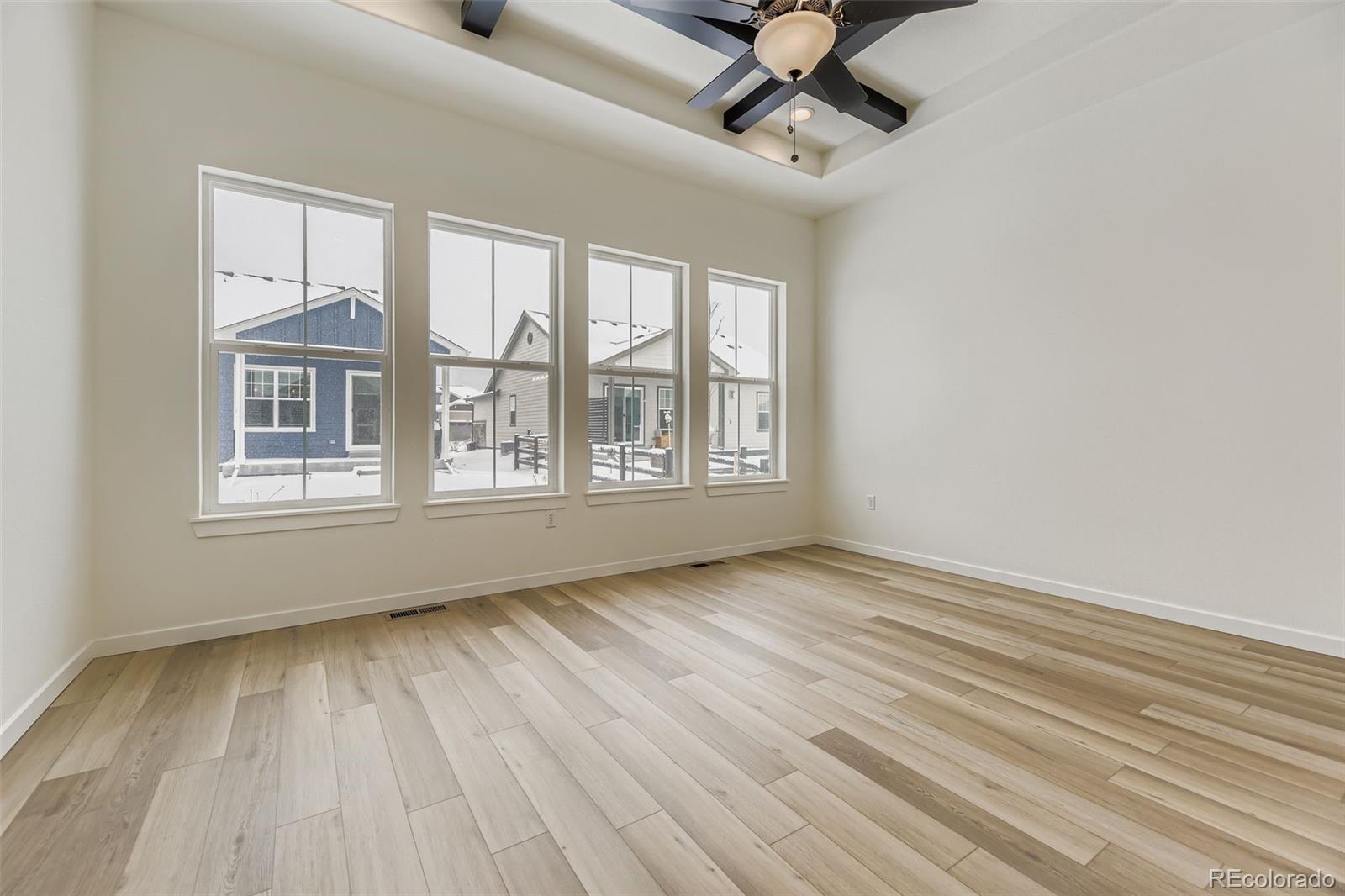 8902 South Riviera Way Aurora, CO 80016 - Photo 13 of 26 a view of an empty room with a window and wooden floor