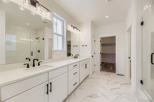 a bathroom with a double vanity sink mirror and shower
