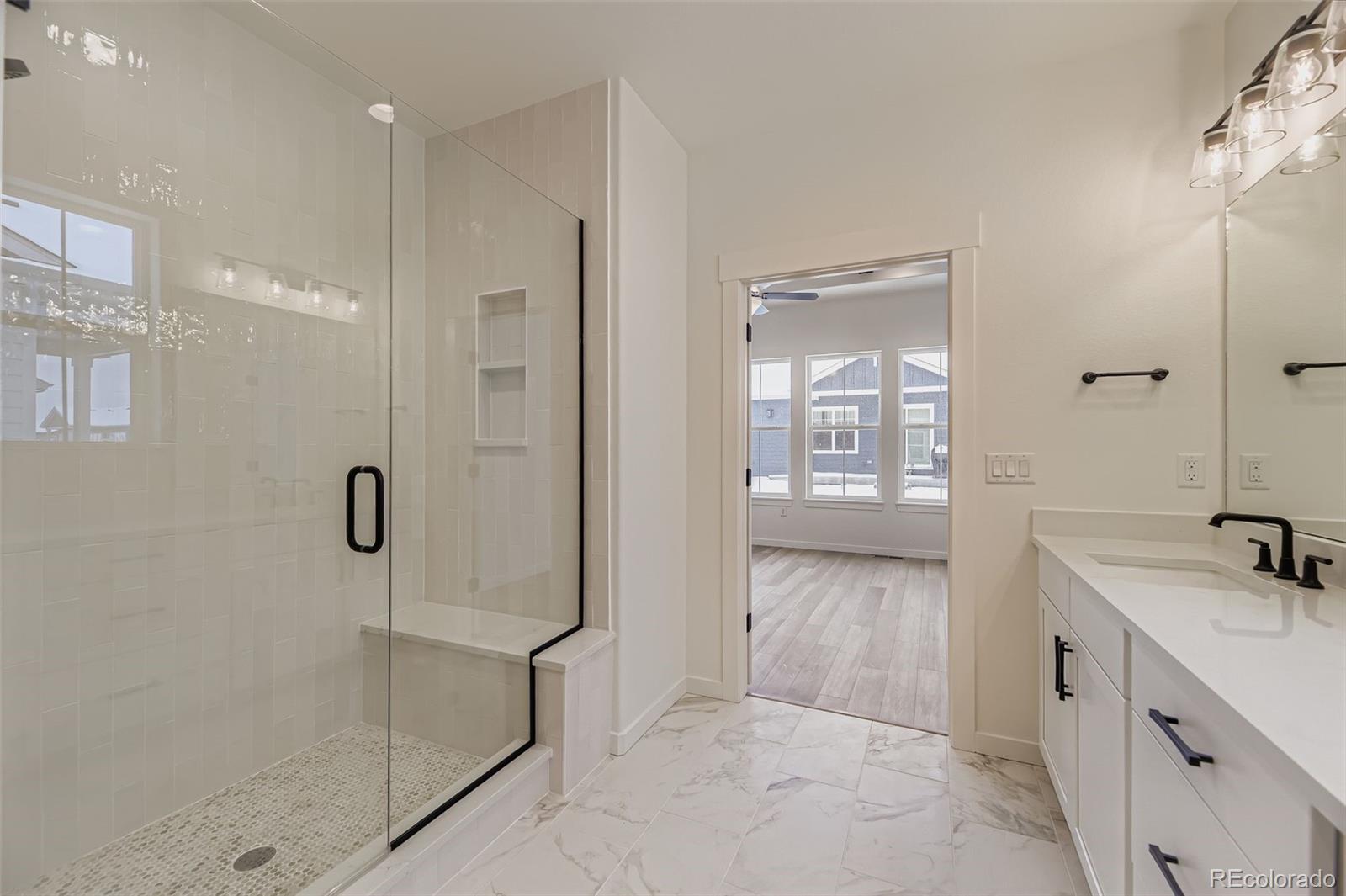 8902 South Riviera Way Aurora, CO 80016 - Photo 16 of 26 a bathroom with a shower sink and mirror