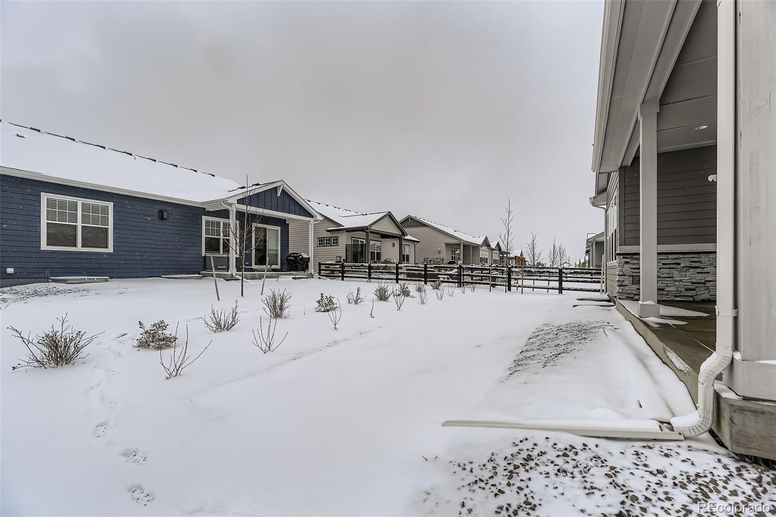 8902 South Riviera Way Aurora, CO 80016 - Photo 23 of 26 a view of a house with a snow in the yard