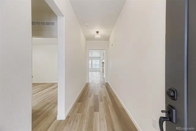 a view of a hallway with wooden floor and entryway