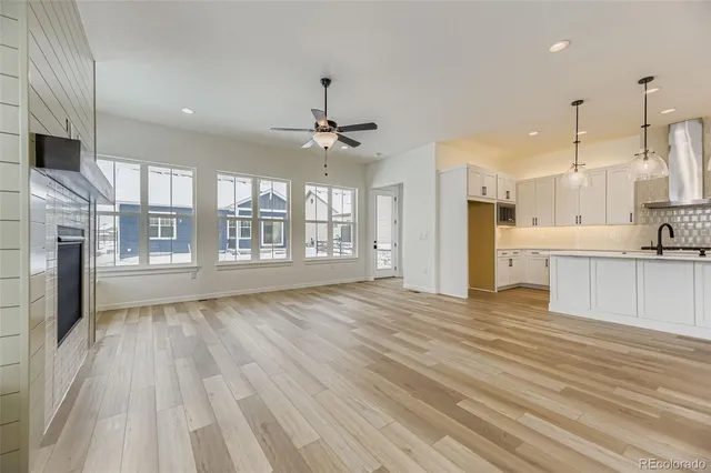 a view of large kitchen with a sink and wooden floor