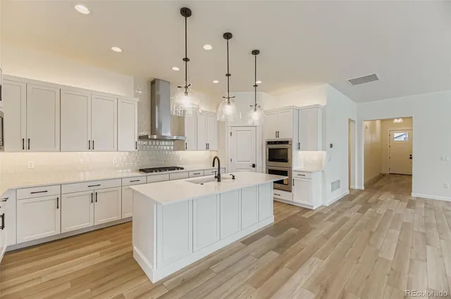 a large kitchen with white cabinets and stainless steel appliances