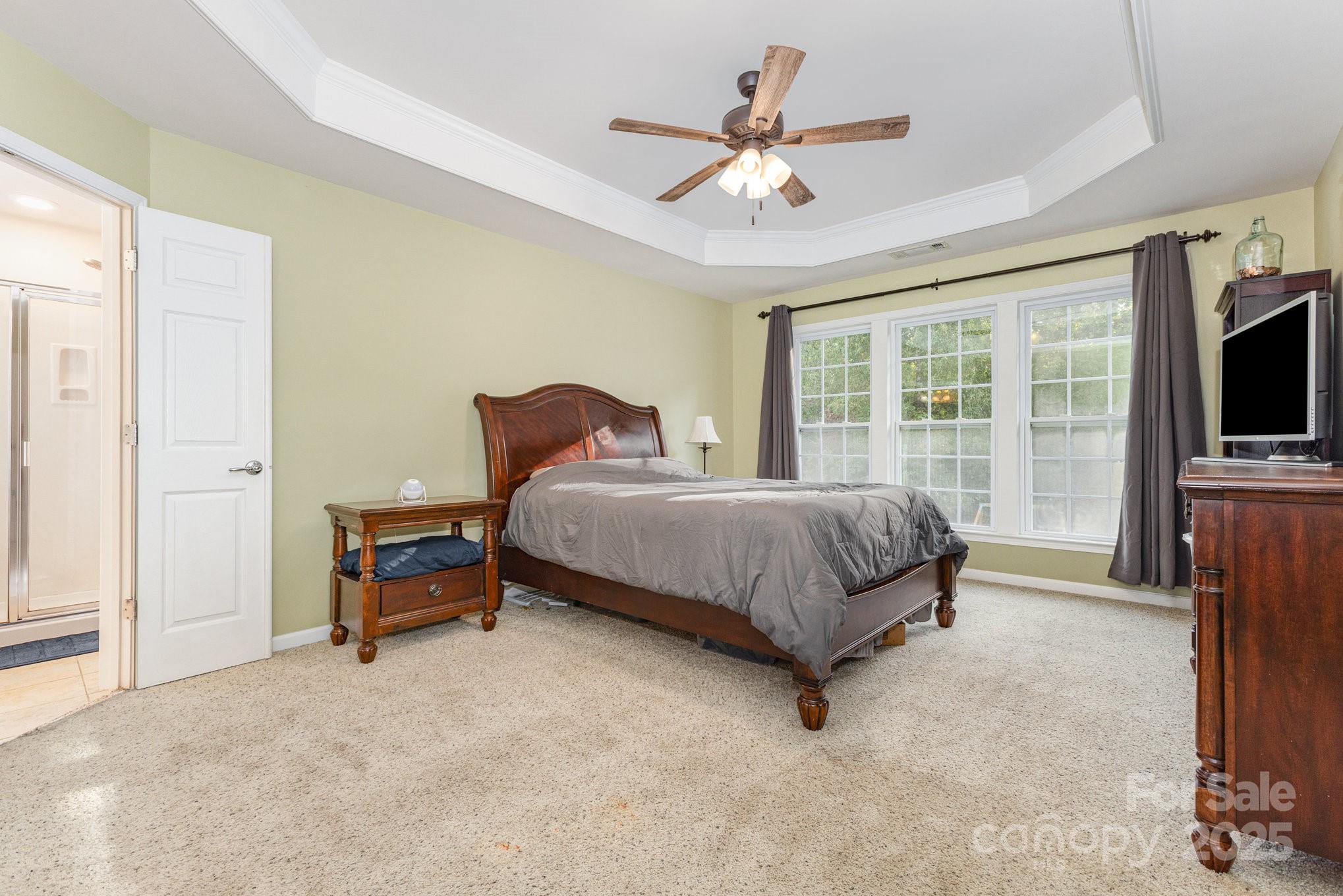 3384 Dunbar Lane Fort Mill, SC 29707 - Photo 19 of 34 a bedroom with a bed a flat screen tv and a fireplace