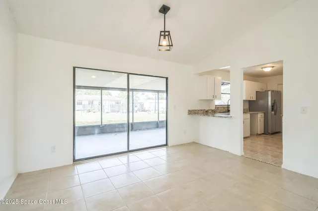 a view of kitchen with refrigerator and window