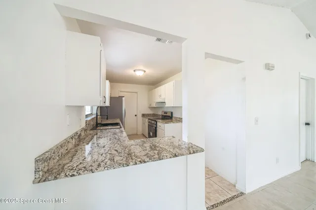 a kitchen with a sink refrigerator and microwave