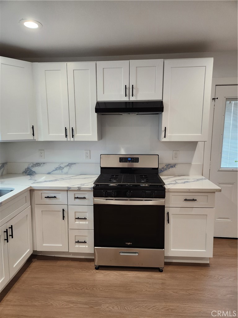 841 East H Street Colton, CA 92324 - Photo 6 of 23 a kitchen with stainless steel appliances granite countertop a stove and a white cabinets